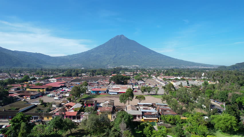 Aerial view of Antigua Guatemala by DJI air2s drone above the city, revealing beautiful architecture and landscape of the city. sunny sky volcano, Fuego, in the background. | Shutterstock HD Video #1099544301
