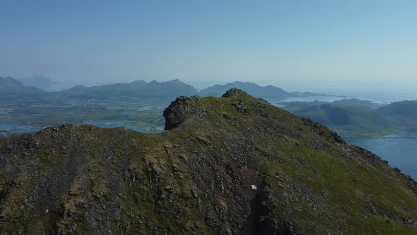 Low pass of peak in Lofoten with the city of Leknes in the background. Mountain is called Nappstraumstinden and is located in Napp, Lofoten. Captured summer 2022 | Shutterstock HD Video #1099548543