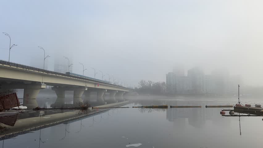 Winter Kyiv metro bridge in the fog reflection train in the river Dnipro