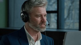 Close-up elderly caucasian man talk using headset with microphone mature businessman leader negotiating making video conference presentation online male call center operator consulting client helpline - Powered by Shutterstock - Get 15% off with code: PIKWIZARD15