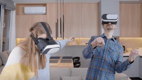Young couple, a man and a woman, play at home, have fun, use a virtual helmet. People wearing glasses and a virtual reality helmet. People, a young couple, use VR. 