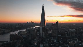 Cinematic take, Aerial View Shot of London UK, United Kingdom, magical sky, Shard, London Bridge Station, super clear image, perfect tones, London skyline, slow circling left, sunrise sunset