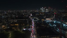 Establishing Aerial View Shot of London UK, United Kingdom, night evening, traffic, busy city, Cnary Wharf in the background
