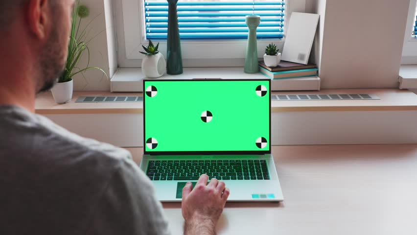 Videocall. Rear view of man watching at green screen of laptop. Copy space and mock up with chromakey. Concept of business and remote online work. Royalty-Free Stock Footage #1099556179
