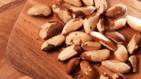 Brazilian nuts on a wooden table. Close up 4k video with healthy nuts rich in Selenium and other vitamins and proteins, pan camera movement.