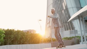 Active cool happy older senior business man skater wearing suit riding skateboard in city business office district after work on sunset. Old people freedom spirit concept. Slow motion. - Powered by Shutterstock - Get 15% off with code: PIKWIZARD15