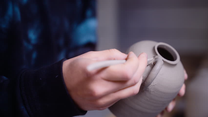 Potter puts the finishing touches on clay vase in her worksop close-up on vase | Shutterstock HD Video #1099559069