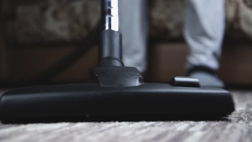 Person using vacuum cleaner cleans the carpet on the floor does house cleaning, close-up | Shutterstock HD Video #1099559805