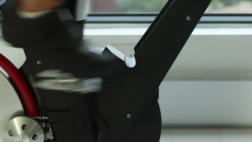Exercise bike indoor. Closeup of spinning wheels. Woman exercising at home on spin indoor bicycle doing fitness workout