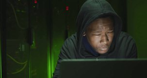 Animation of data processing over african american male hacker with computer and computer servers. Global online virus, computing and data processing concept digitally generated video.