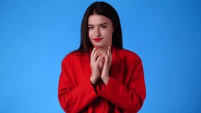4k video of girl with cunning facial expression on blue background.
