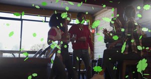 Animation of st patrick's day green shamrock falling over diverse friends having fun at party. St patrick's day, irish tradition and celebration concept digitally generated video