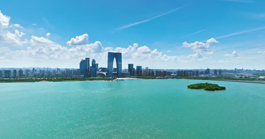 Aerial footage of city skyline and modern buildings with lake natural scenery in Suzhou, China.