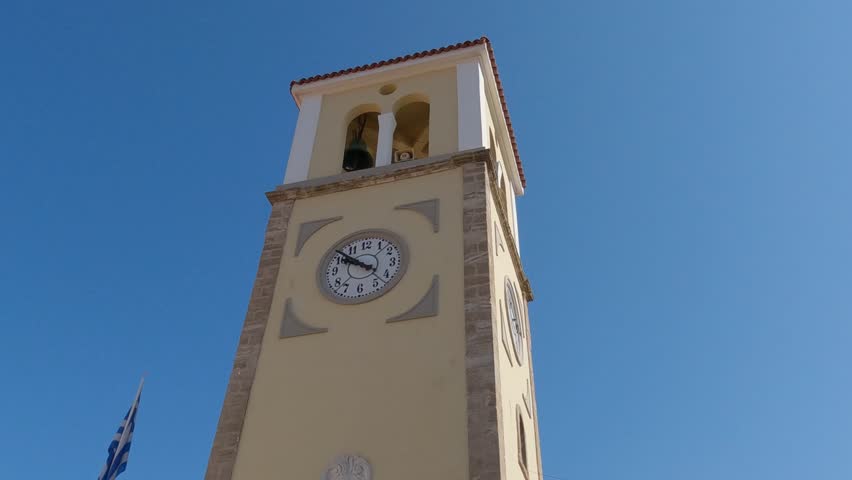 Saint charalambos church, an old historic yellow and brown building with a white clock in Preveza, Greece.