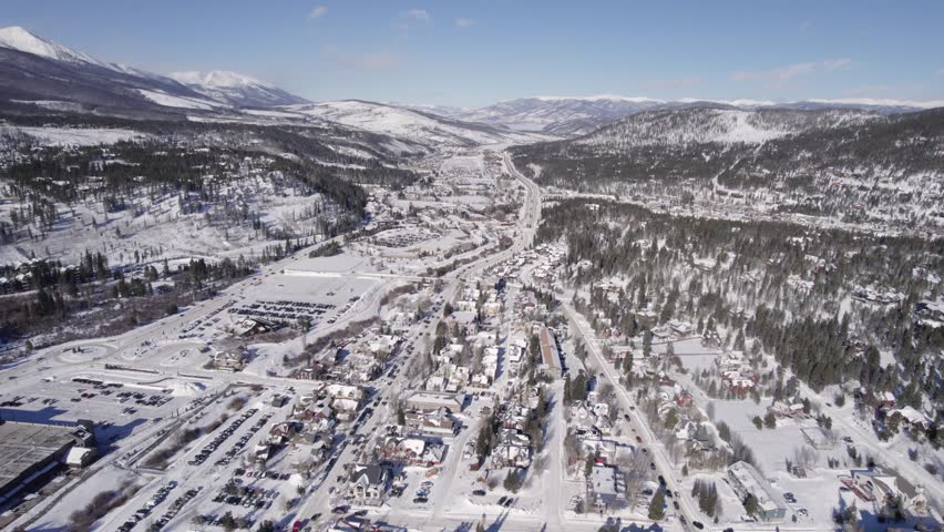 Aerial Footage of snowy Silverthorne, Colorado during Winter. Town and Forest. Daytime. Pushing in.