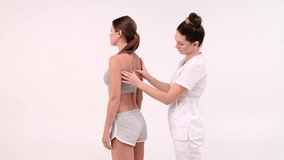 Back and shoulder of woman being massaged by hands of a masseuse. Rearview of female customer getting an assessment from a physio on white background. Massaging to get rid of stress and tension - Powered by Shutterstock - Get 15% off with code: PIKWIZARD15