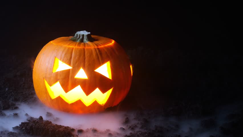 Scary background for Halloween celebration. A pumpkin with a face cut out is smoking. | Shutterstock HD Video #1099579425