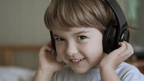 Portrait of Cute Little Boy With Headphones Listening to Music. Slow Motion Of Child On Relaxing on With Eyes Closed Wearing Headphones. Kid Listening to Music in Home. Cheerful Carefree Childhood. - Powered by Shutterstock - Get 15% off with code: PIKWIZARD15
