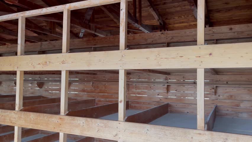 Wooden bunk beds inside barracks at Dachau Concentration camp in Germany. Holocaust museum memorial site concept