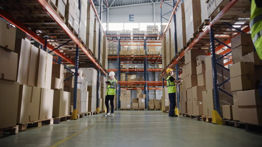 Retail Warehouse full of Shelves with Goods in Cardboard Boxes, Workers Scan and Sort Packages, Move Inventory with Pallet Trucks and Forklifts. Product Distribution Logistics Center. Dolly Shot | Shutterstock HD Video #1099585775