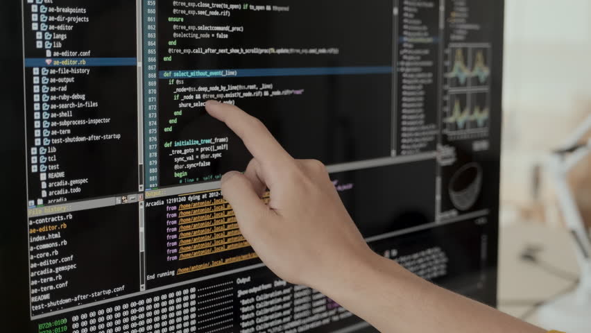 Unrecognizable software developer reading program code on black screen of computer monitor