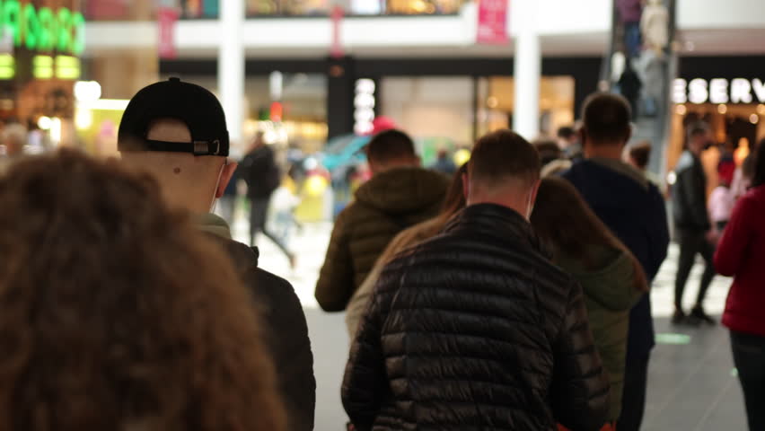 Queue of people, crowd waiting, line inside. Group of people are standing in queue indoors in shopping mall, waiting for something to happen. Royalty-Free Stock Footage #1099587695