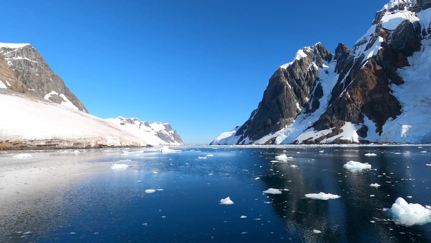 Smooth water surface and snowy mountain peaks in Antarctica time lapse. Time lapse Antarctica landscape with water surface and snow-capped mountains. | Shutterstock HD Video #1099592951