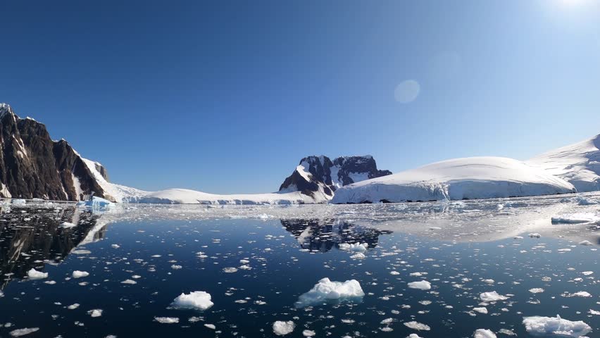 Time lapse Antarctica landscape with water surface and snow-capped mountains. Amazing calmness characteristic of Antarctica is given by clear blue sky. | Shutterstock HD Video #1099593011