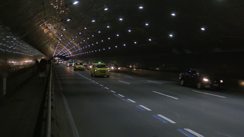 Cabs and cars drive through a lighted tunnel in Porto Alegre at night, in Brazil