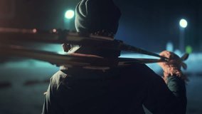 Cross country ski. Young woman holds ski on her shoulder and stands on the night highlighted stadium. Camera orbits - Powered by Shutterstock - Get 15% off with code: PIKWIZARD15