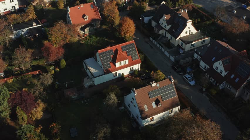 Drone shot over solar panels Photovoltaic solar panels mounted on the red roofs of country houses absorb sunlight as an energy source to generate electricity Royalty-Free Stock Footage #1099597189