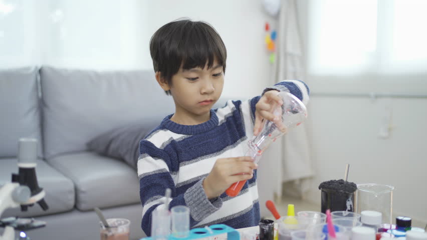 An Asian student kid study, learn on test tube in lab or laboratory in school, medical, chemistry. Experiment science. Education in classroom. People lifestyle - Powered by Shutterstock - Get 15% off with code: PIKWIZARD15