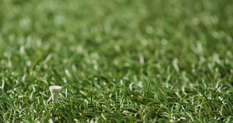 Close up of hand with glove holding golf ball on grass, copy space, slow motion. Golf, sport and hobby concept.