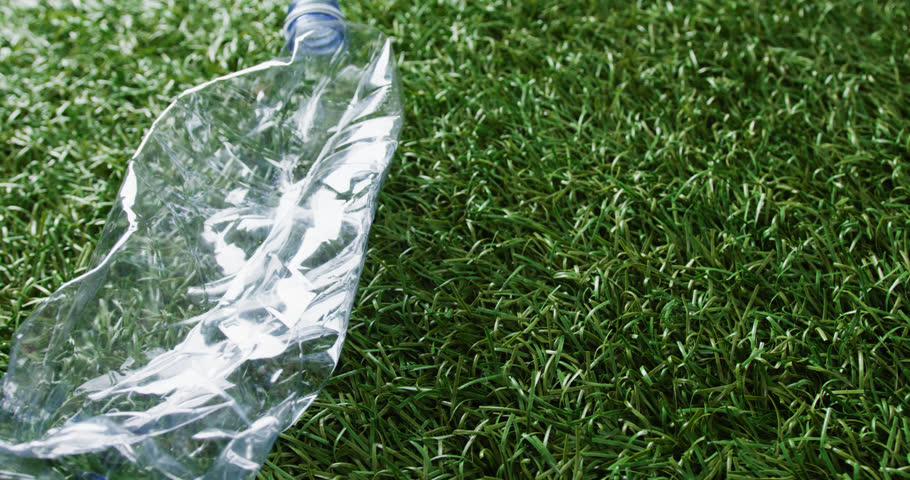 Close up of plastic bottle trash on grass background, with copy space. Global recycling, ecology and nature concept. | Shutterstock HD Video #1099599501