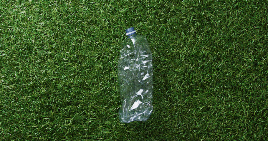 Close up of plastic bottle trash on grass background, with copy space. Global recycling, ecology and nature concept. | Shutterstock HD Video #1099599553