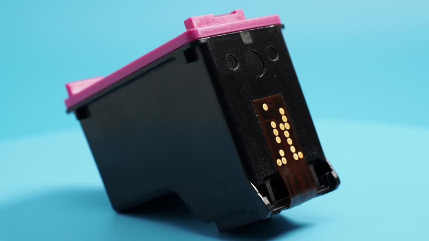 Rotating cartridge with printer ink on a blue background. Close-up.