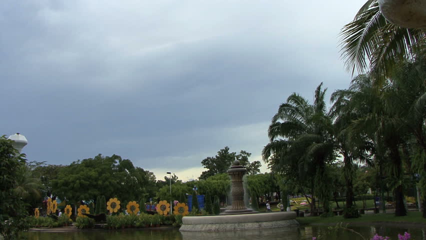 A tilt down shot of a pretty fountain in the middle of a lovely pond in Asia.