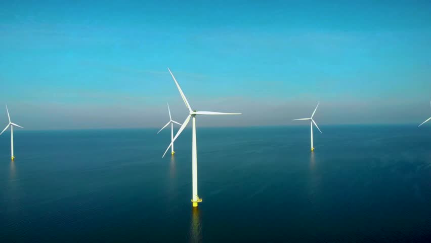 Windmill turbines at sea generate green energy in the Netherlands. Drone view at windmill park in the ocean | Shutterstock HD Video #1099607477