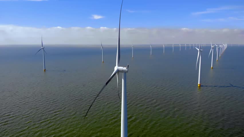 Offshore windmill park green energy with clouds and a blue sky, windmill park in the ocean aerial view with wind turbine Flevoland Netherlands Ijsselmeer | Shutterstock HD Video #1099607481