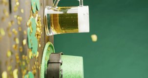 Vertical video of of st patrick's green hat, beer and champagne glasses on green background. St patrick's day, irish tradition and celebration concept.