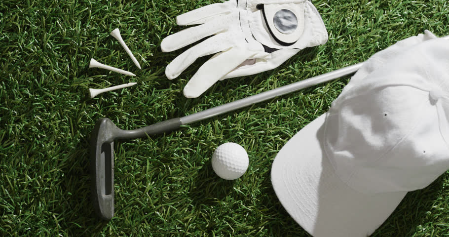 Vertical viedo of golf ball, glove, peaked cap, tees and club on grass, copy space, slow motion. Golf, sport and hobby concept. | Shutterstock HD Video #1099607967
