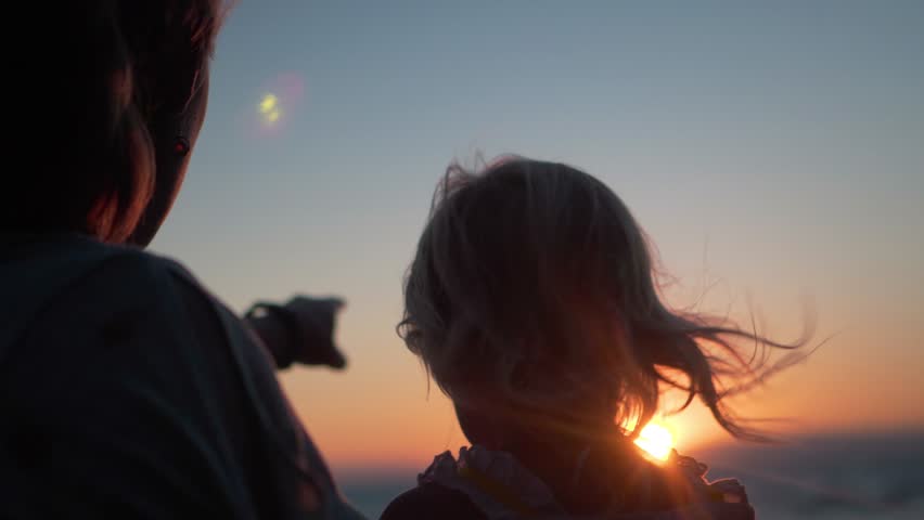 Silhouette Shot of Mother and Daughter Pointing at Sunset, Smiling at Each Other | Shutterstock HD Video #1099608473