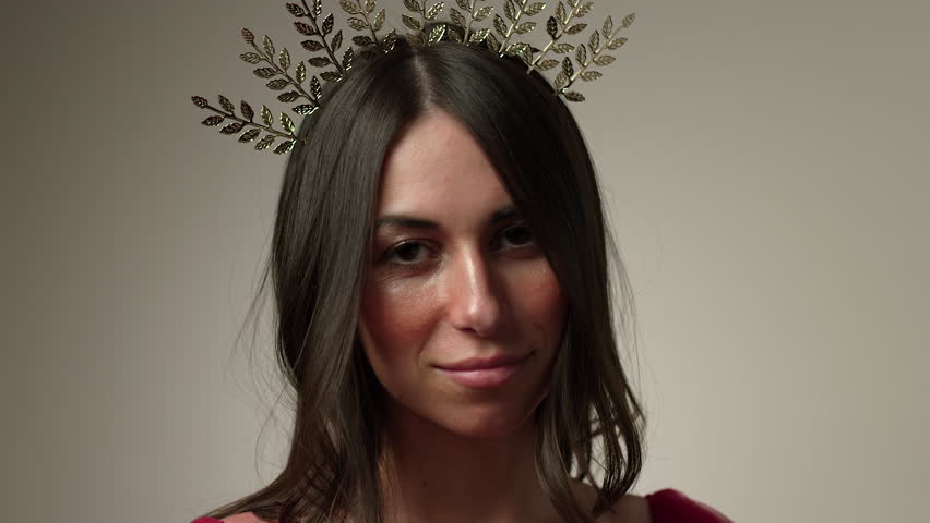 Beautiful woman wearing a tiara smiling looking towards camera - close up on face