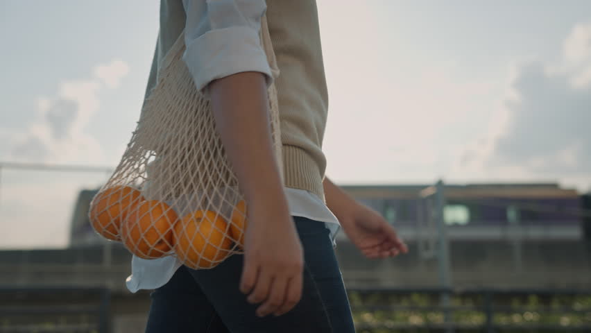 Go green urban life net zero waste carry fruit at eco friendly care store in reuse mesh bag. The way forward Save the earth no plastic free reduce trash people walk in sun light city metro rail train. | Shutterstock HD Video #1099615489