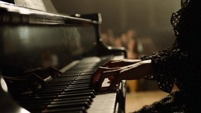 Footage Of Female Pianist Plays In Beautiful Grand Piano On Stage In Concert . A woman plays the piano in the concert hall . Many unrecognizable , blurred people in the background .  - Powered by Shutterstock - Get 15% off with code: PIKWIZARD15