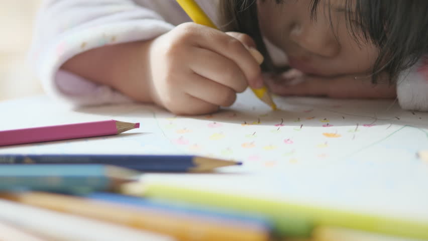 Asian little girl is drawing with colored pencils. Mountain scribble. Kid in winter loungewear. Child growth. Lifestyle | Shutterstock HD Video #1099619875