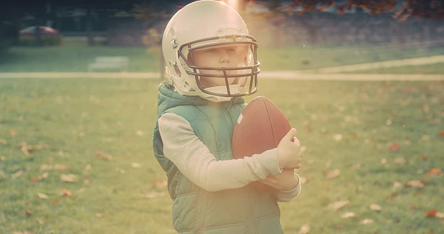 Family fun outdoors, Cheerful happy child in helmet playing American football outdoors in sunny day at public park. Family sports weekend. 4K video. Royalty-Free Stock Footage #1099623657