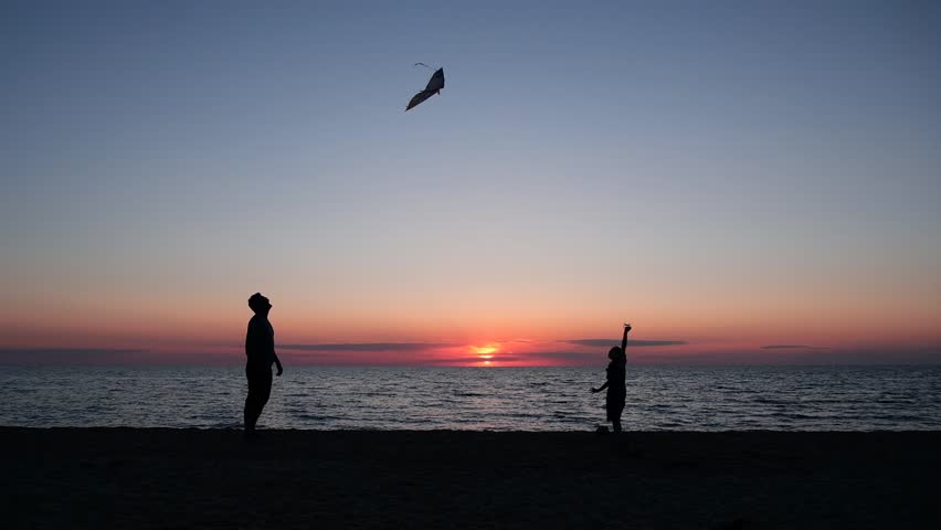 Happy family father and child daughter run with kite in the meadow. silhouettes on the background of the sea sunset. High quality photo. | Shutterstock HD Video #1099623993