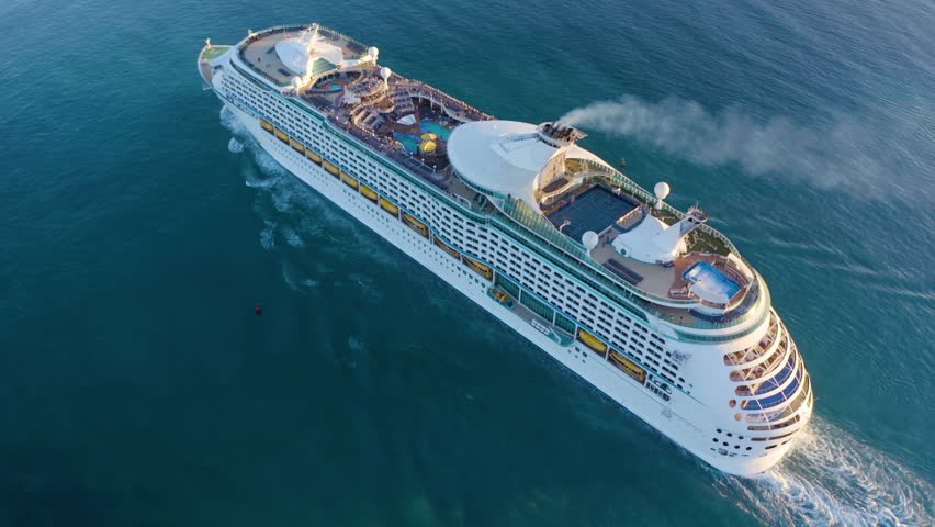 Aerial view of the cruise ship in open water. Cruise liner sailing the ocean or sea on a sunny summer day. Aerial top view of luxury large cruise ship sailing full speed on open water, luxury vacation Royalty-Free Stock Footage #1099624535