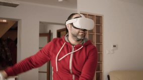 Man on Virtual Reality Glasses Doing Variation of Online Fitness Training. Man Wearing Virtual Reality Headset Holding Gaming Controllers. Sportsman in VR Headset Working Out at Home. 